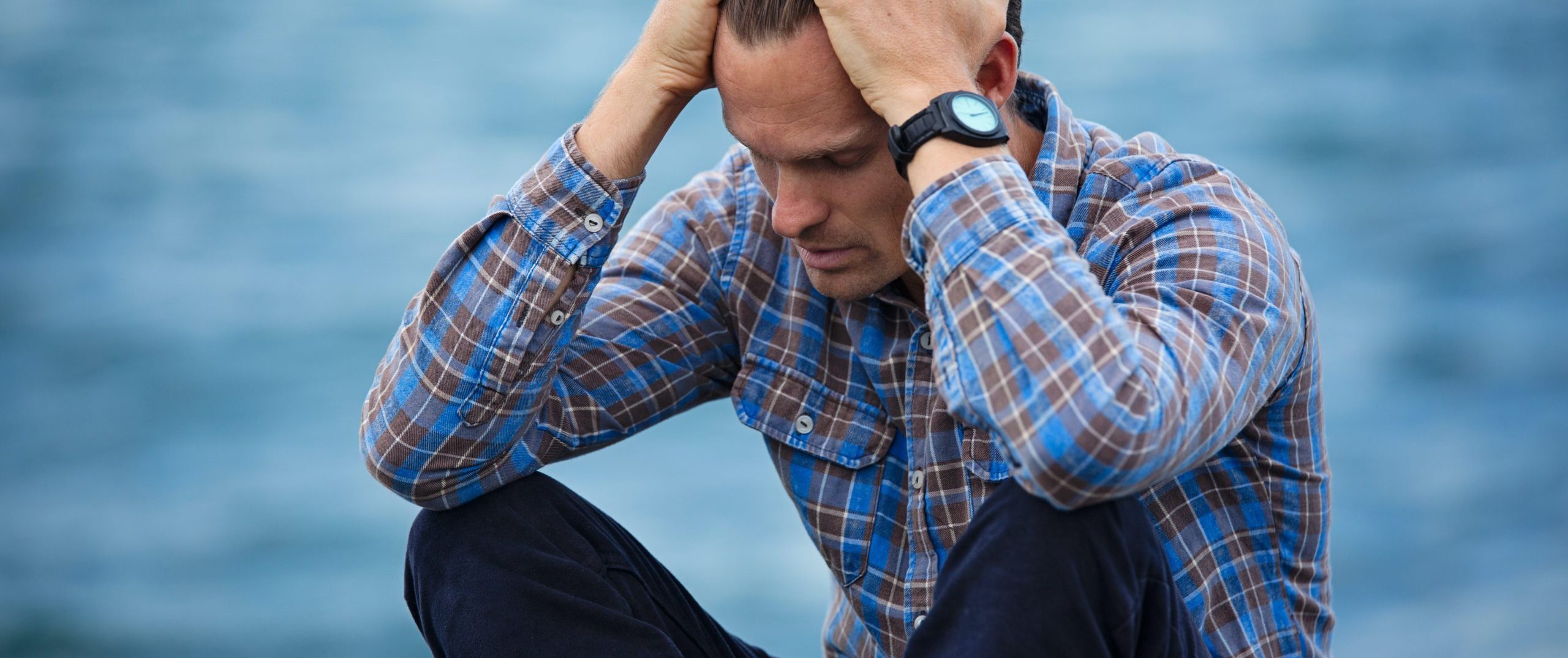 man-in-blue-and-brown-plaid-dress-shirt-touching-his-hair-897817